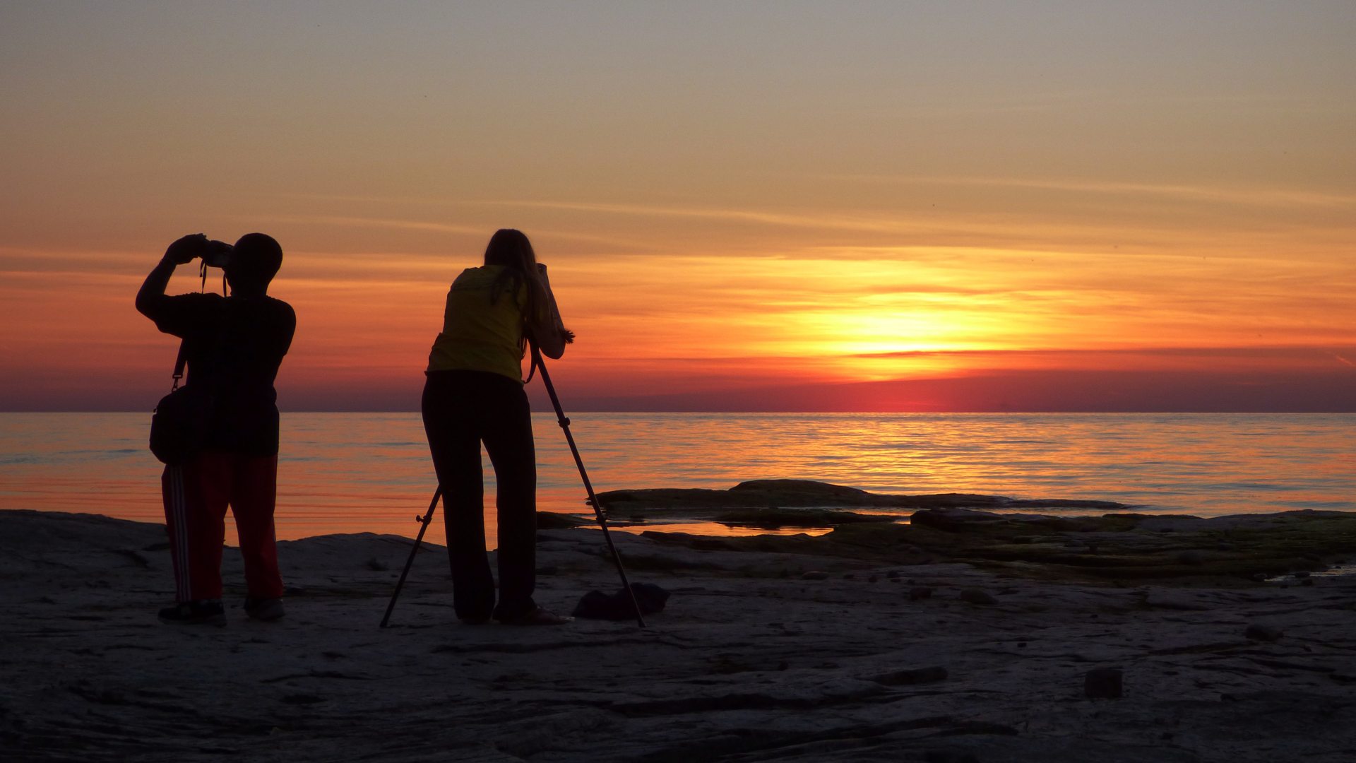 students taking pictures of a lake ontario sunset