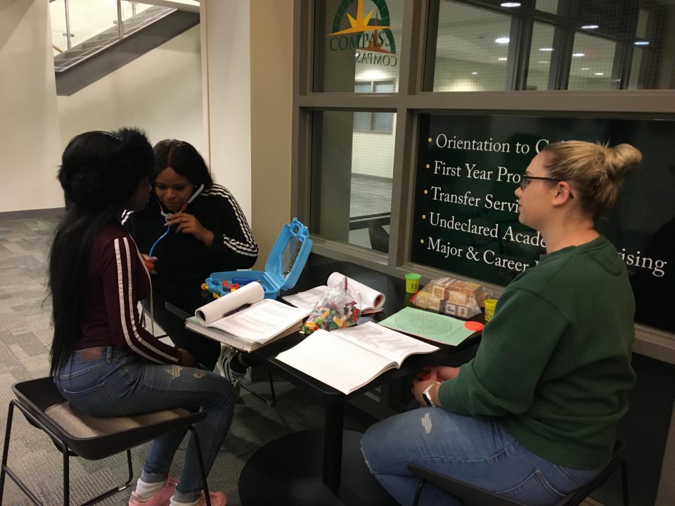 Students sitting at a table outside of the Compass office