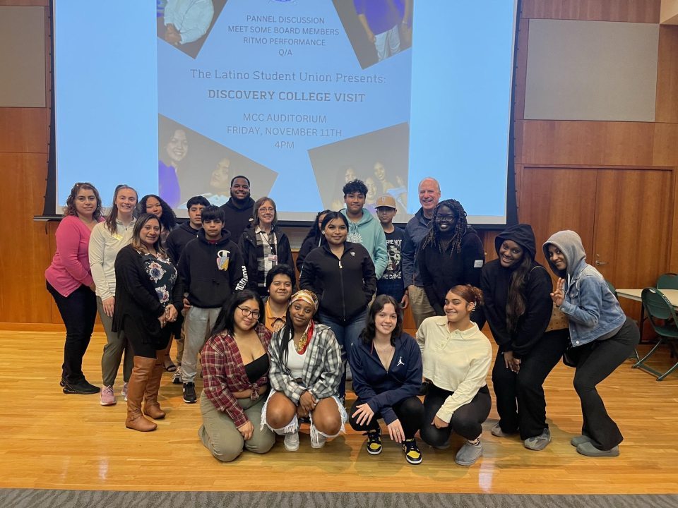 A group of Latino/a students in front of a projection screen
