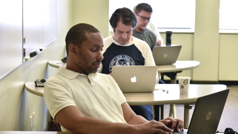 Students working on their laptops in the classroom