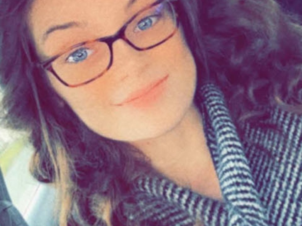 Young woman wearing glasses and a striped shirt.