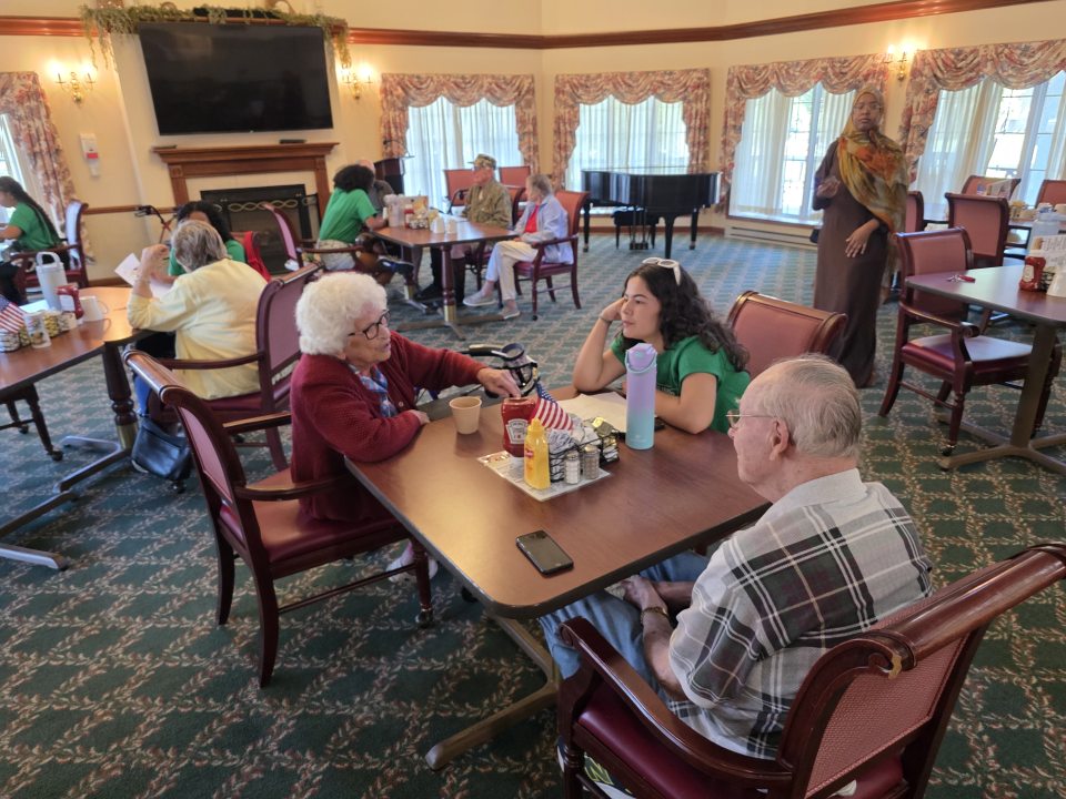 Student chatting with residents at Bishop Commons