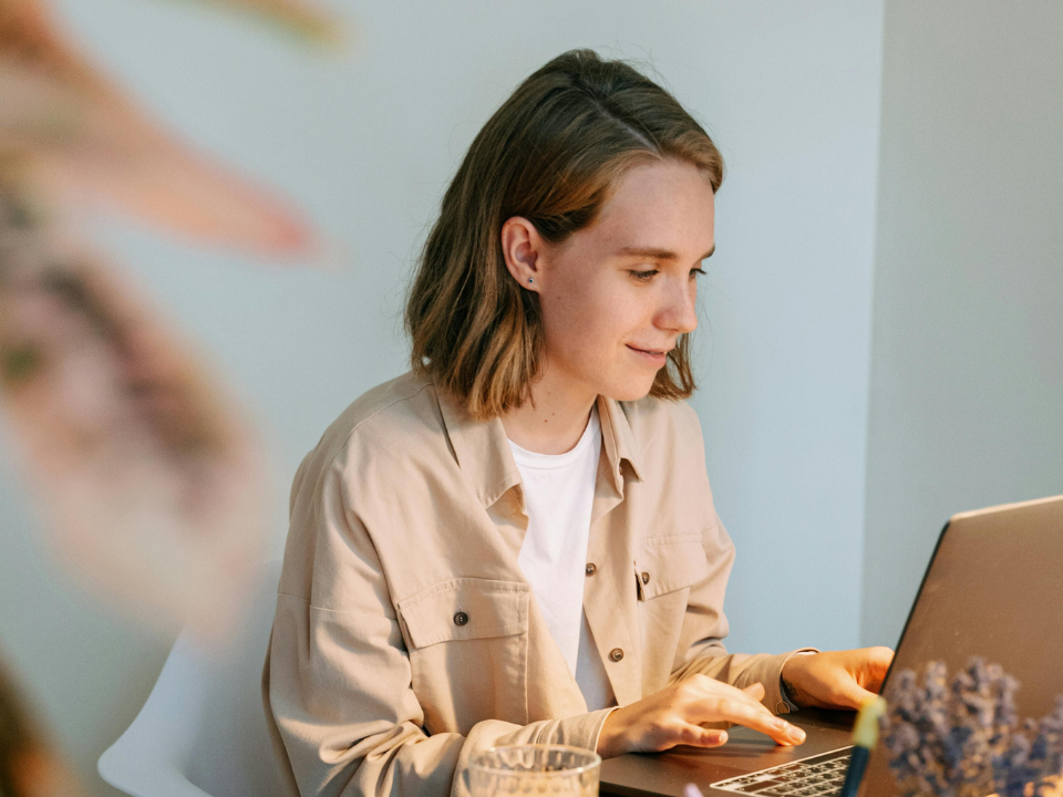 woman sitting at cluttered desk in front of computer
