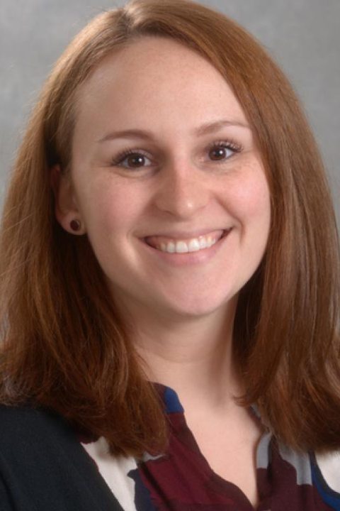 Portrait headshot of emily bovier against a gray background