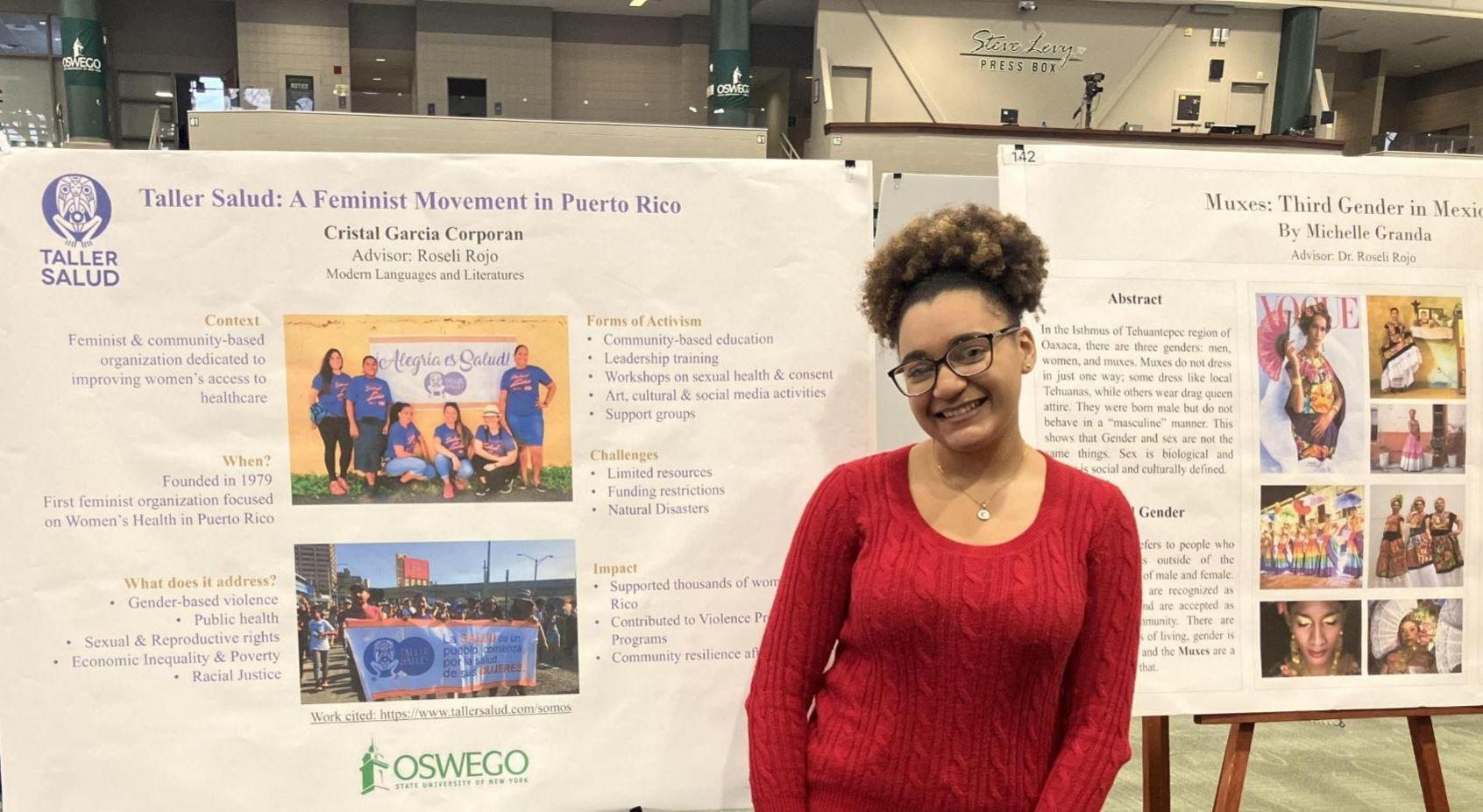 Student presenting at Quest standing in front of their poster titled Taller Salud: A Feminist Movement in Puerto Rico