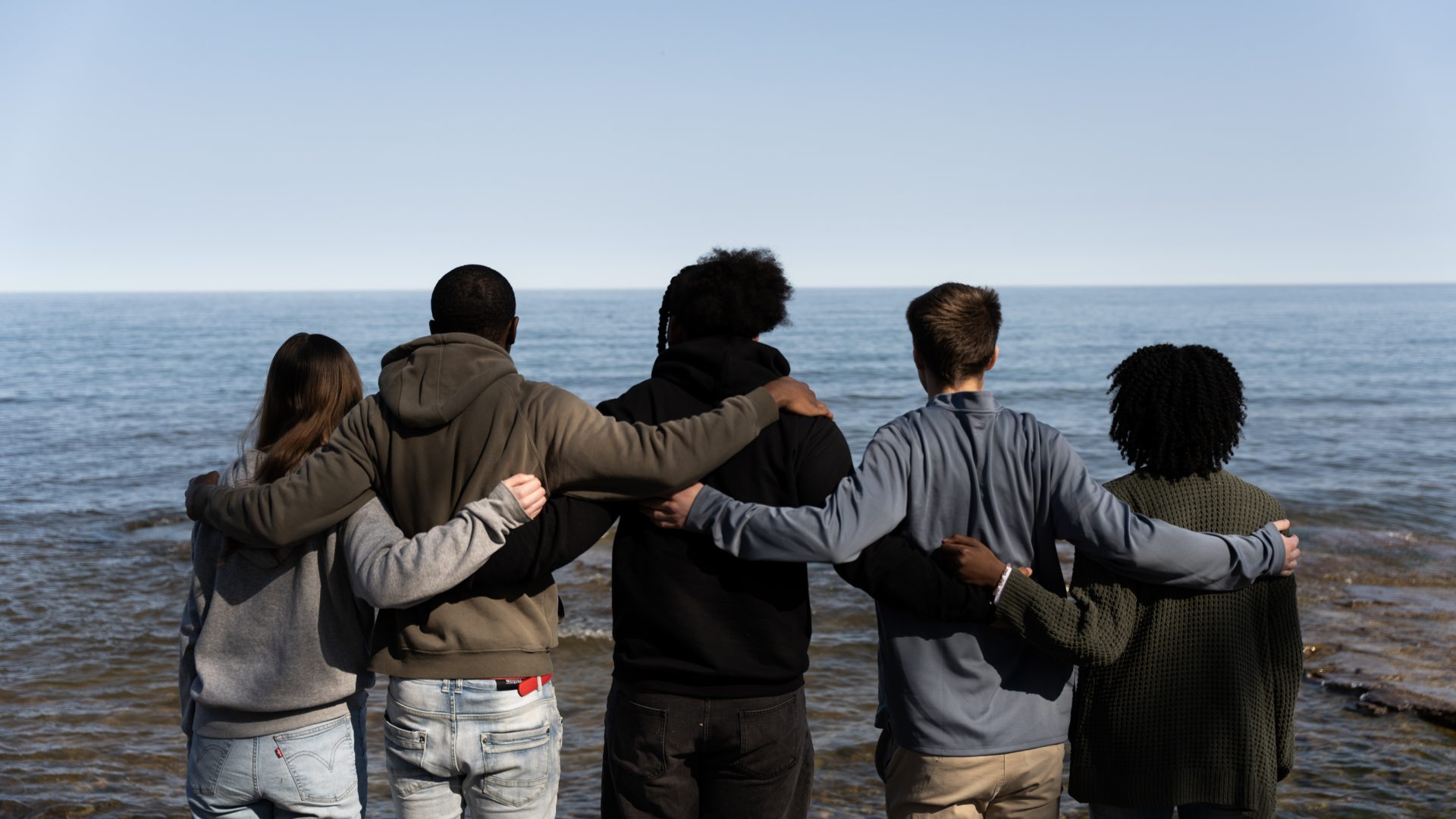 Students stand on the shore of Lake Ontario. (left to right) Stacia Demott, early childhood education, 2028 Jaylen Cameron, marketing, 2025 Joshua Rivera Charles Friedman, accounting, 2025; MBA, 2026 Tatienna Samuels, public relations, 2027 