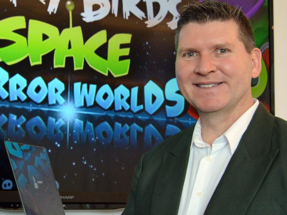 A man in front of an Angry Birds game image