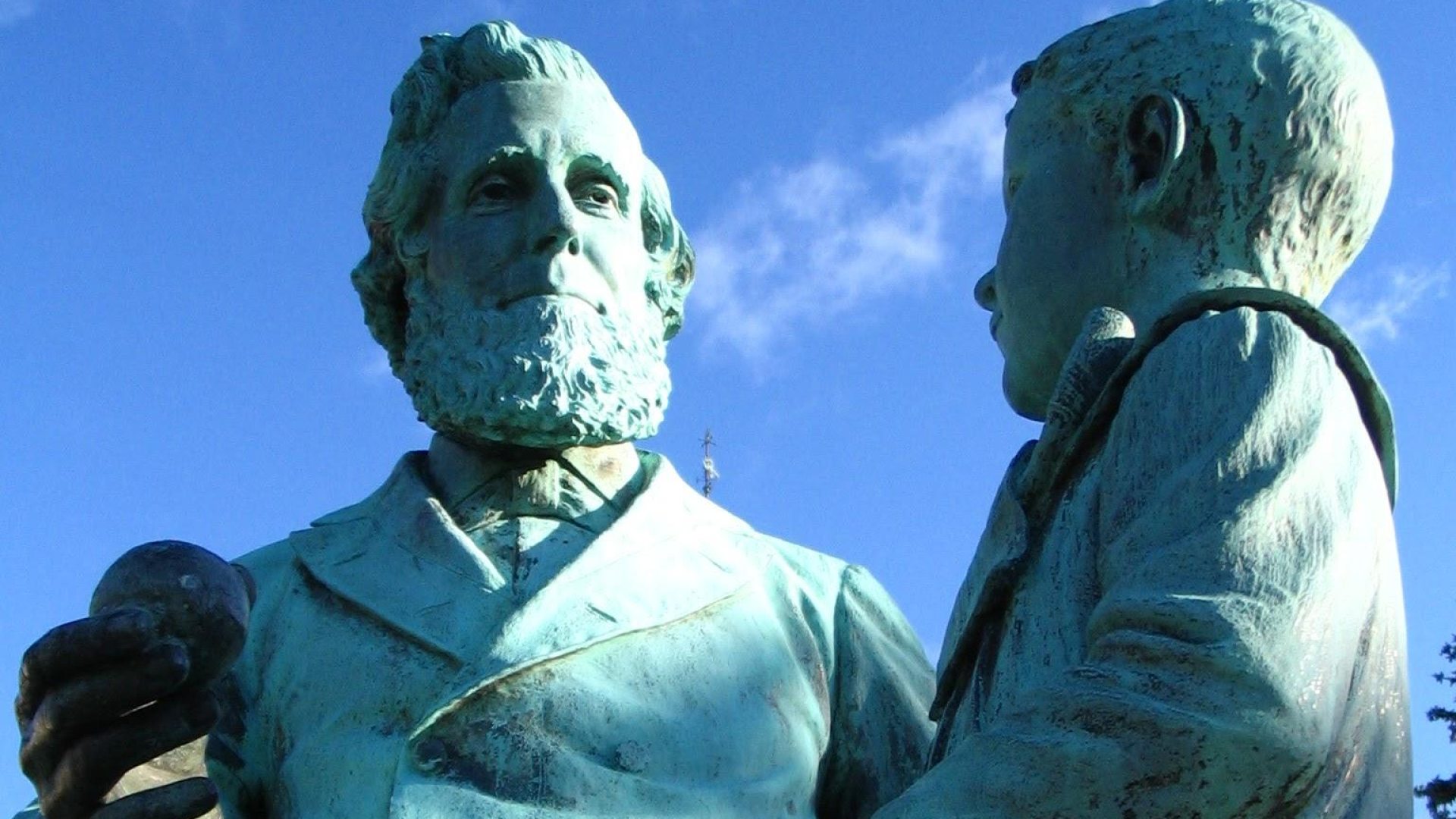 The statue of SUNY Oswego founder Edward Austin Sheldon, who is seated, holding an apple. A young boy stands beside him.