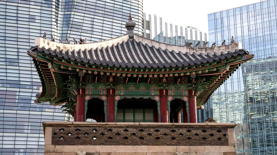 Traditional Korean pavilion in front of modern glass buildings