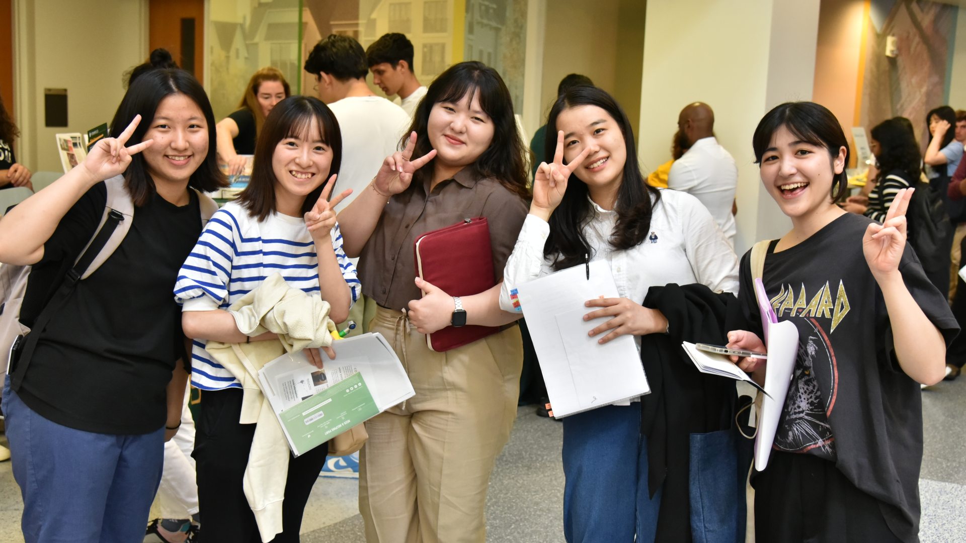 a group of international students giving the camera the peace sign