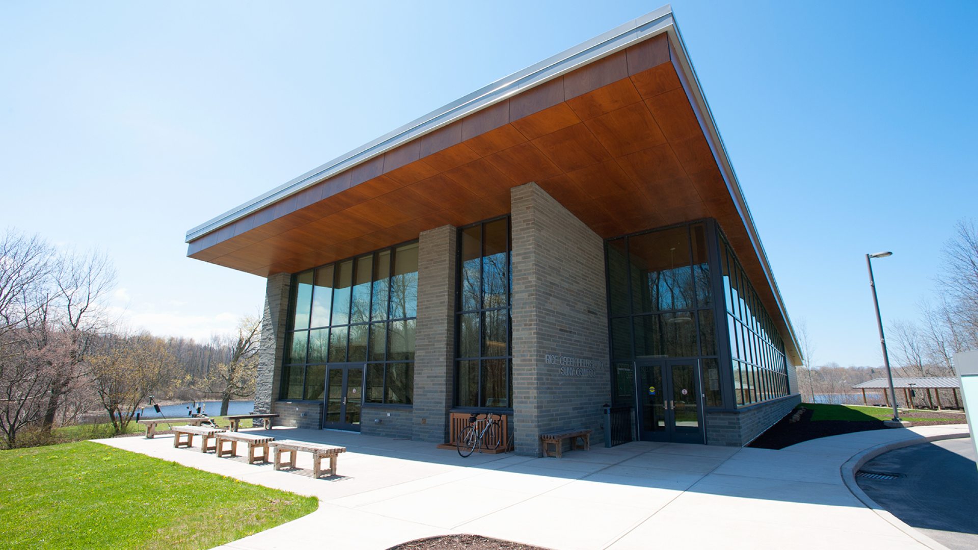 Exterior view of the Rice Creek Field Station building at SUNY Oswego, surrounded by trees and natural landscape.
