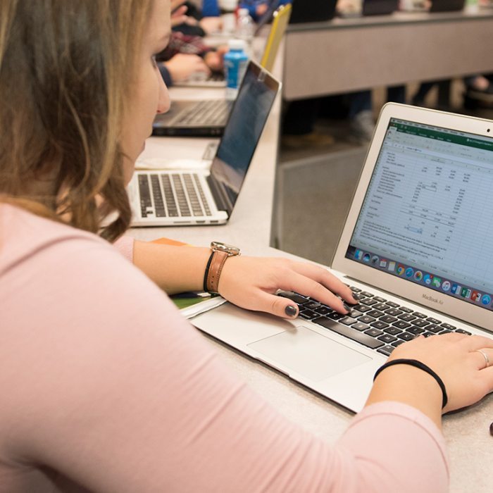 A woman typing on a laptop keyboard