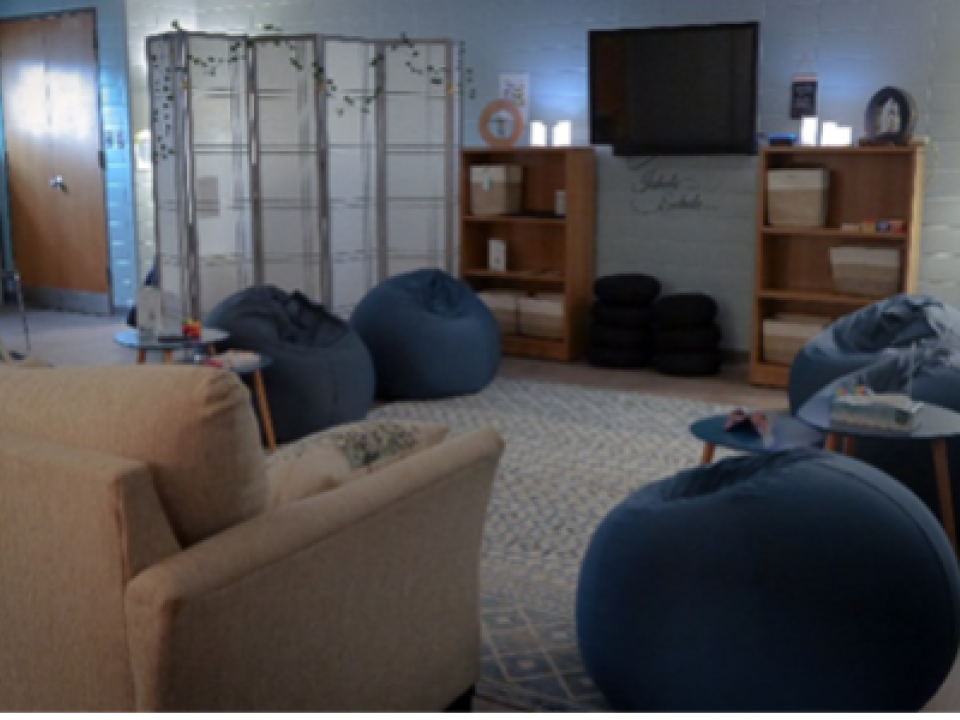 A harmony room, dimly lit with bean bag chairs and a recliner