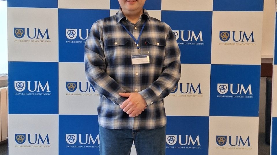 Gonzalo stands in front of a screen for Universidad De Montevideo