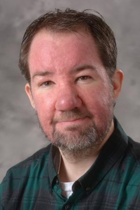 Eric Schmitz wearing a green plaid shirt 