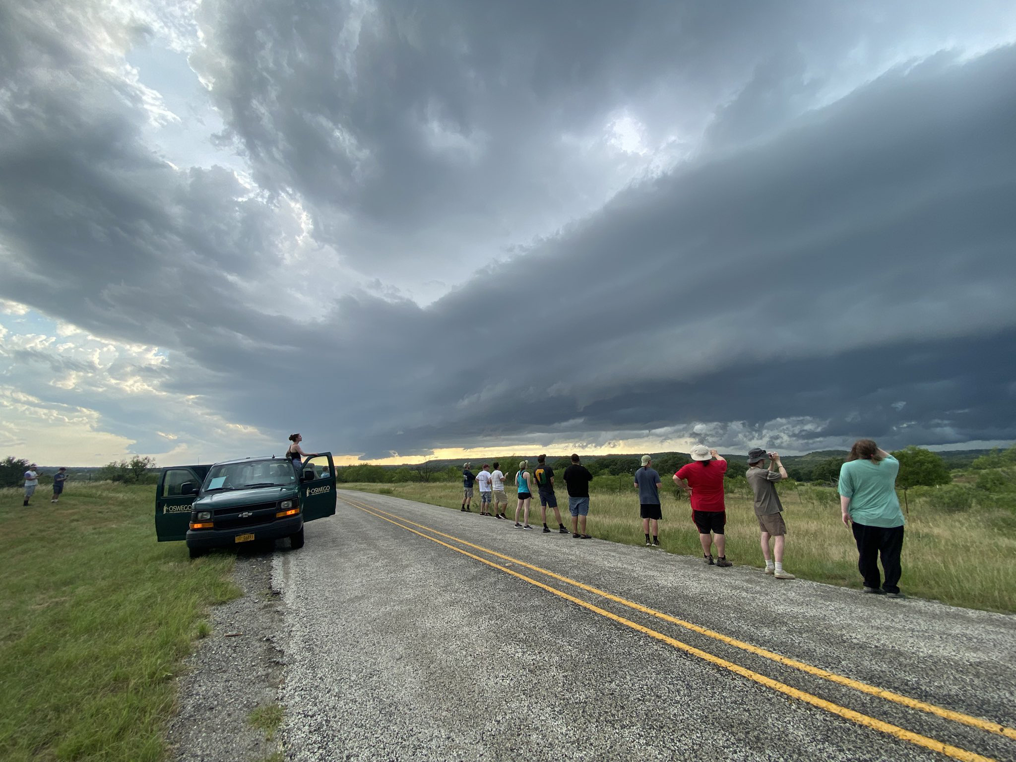 Storm-chasing students line the side of the road while observing a severe storm in