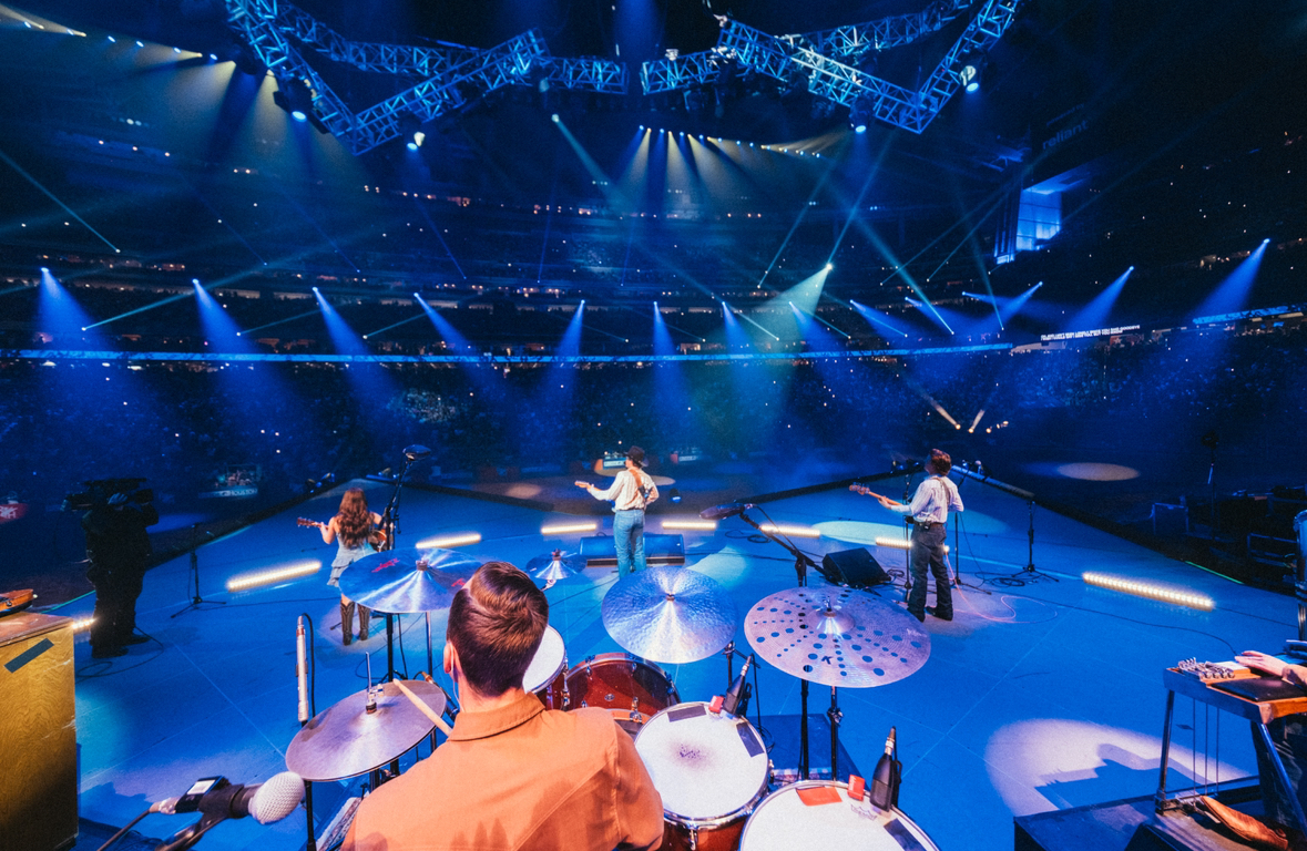 Nate Felty '12 plays drums on stage with country artist Zach Top at NRG Stadium in Houston.