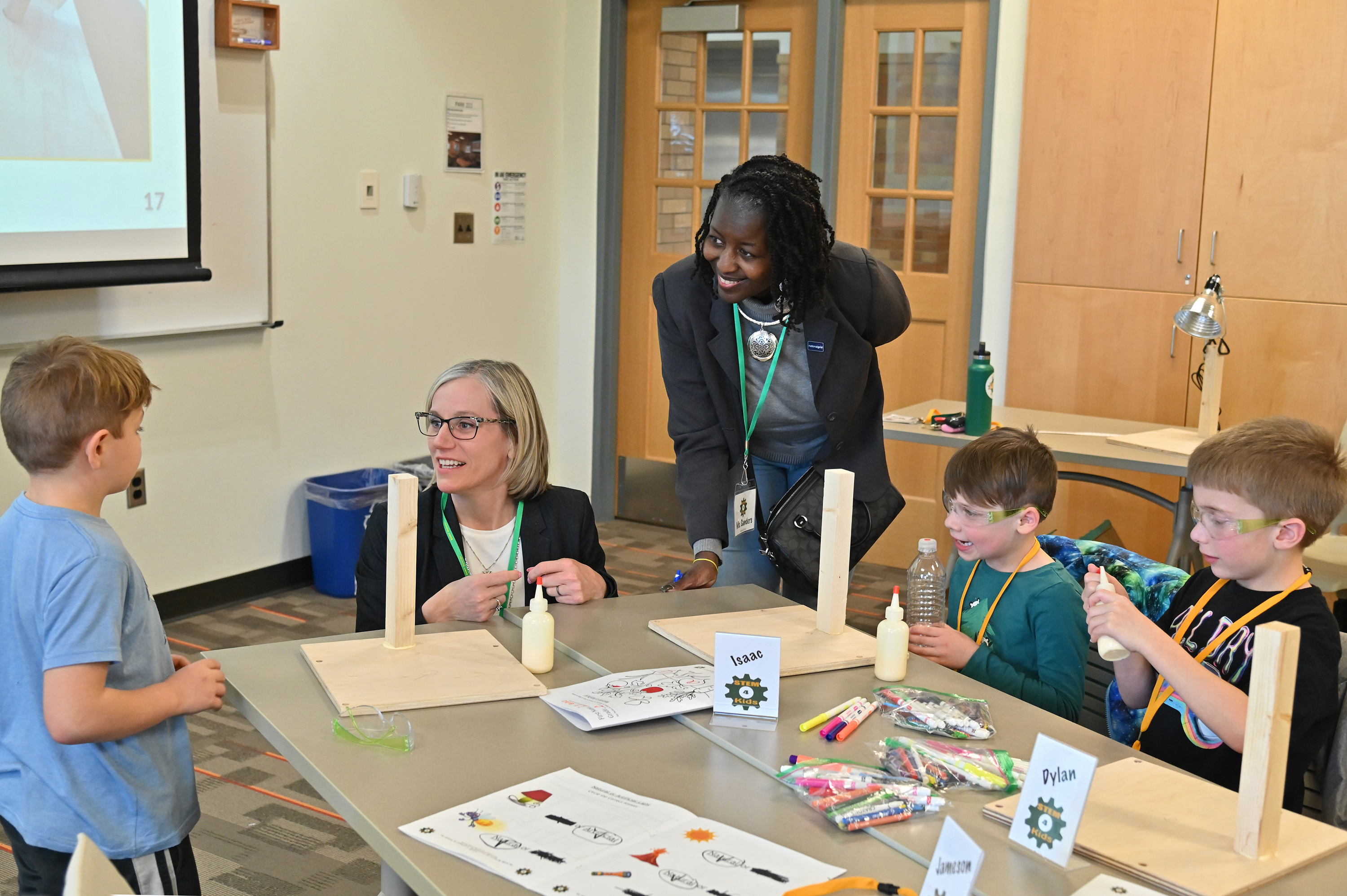 Shown visiting a 2025 edition of KidsTech are Gwen Sanders (center), senior community relations manager within National Grid's Customer and External Affairs, and Laura Spenceley (second from left), dean of the College of Education, Health and Human Services. National Grid continues as a long-time sponsor of the hands-on sessions that support the journey of participating schoolchildren and SUNY Oswego students building their teaching skills. 