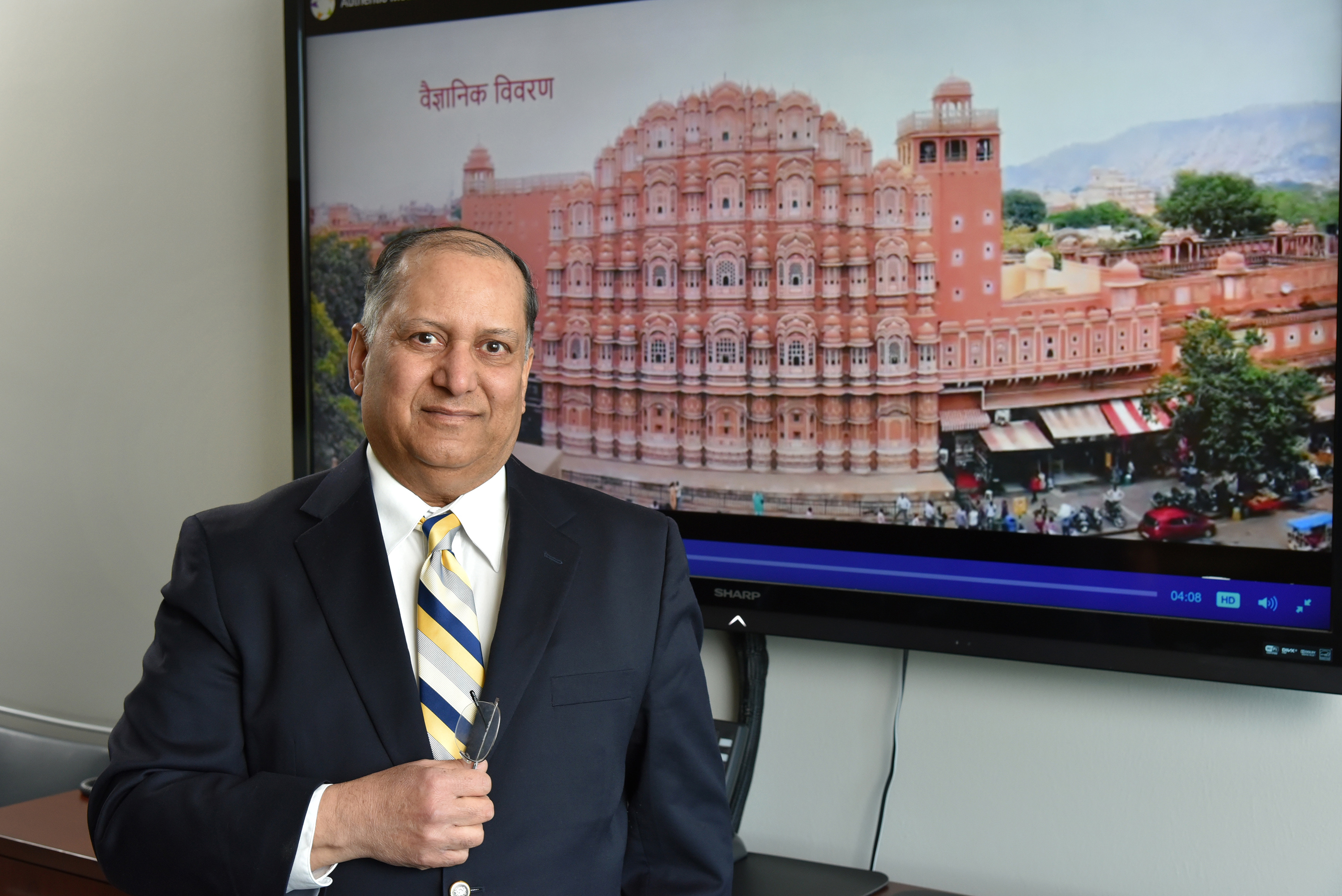 Teaching Hindi -- Dr. Alok Kumar, distinguished teaching professor of physics at SUNY Oswego, worked with a team of scholars to produce 28 videos designed to help middle school through college students learn Hindi. He is pictured with a frame of a video about the Hawa Mahal in Jaipur, a honeycomb structure built in 1799 that employs the "Venturi effect" for natural air conditioning -- a theme that's emblematic of the scientific advances demonstrated by Hindu architecture and inventiveness at some of India's most famous sites.