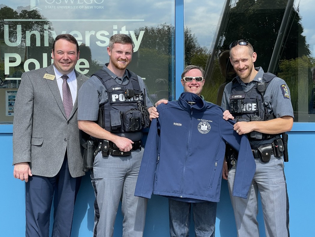 Roger Pullen (third from left) was recently honored by University Police following an extraordinary 35-year career with the campus. Presenting him with a "Car Wash Specialist" fleece are, from left, University Police Chief Scott Swayze, Officer Scott Maynard and Officer Eric Martin.