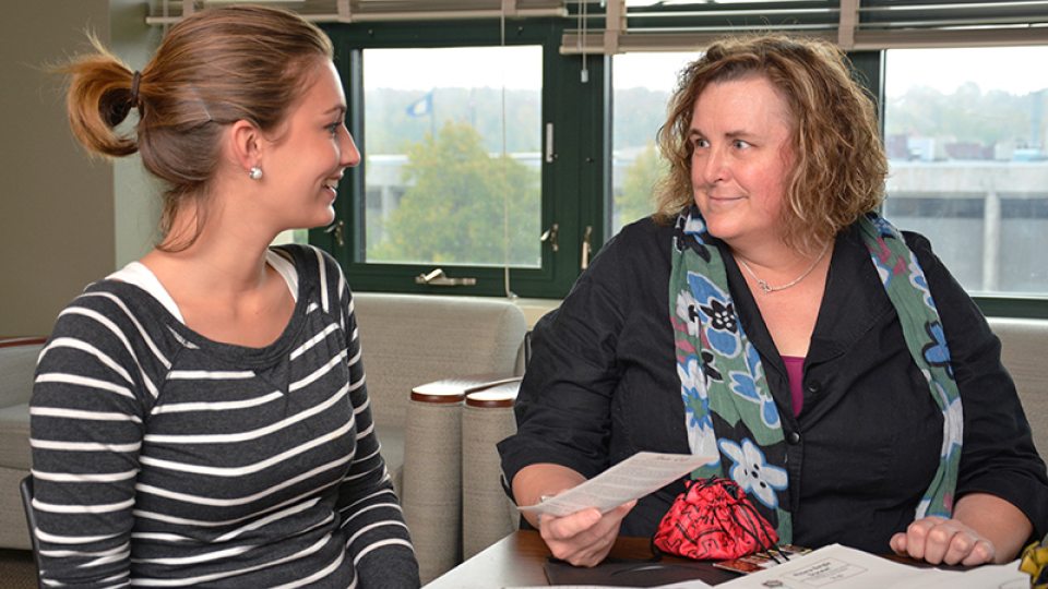 Human development professor and student discussing program