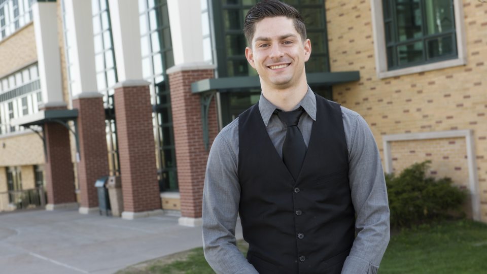 Student in front of Rich Hall