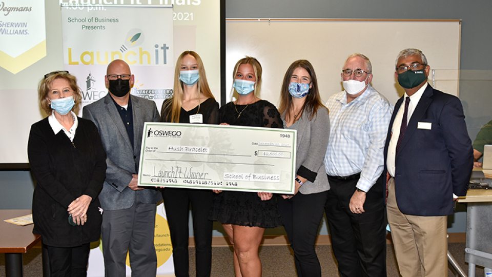 Student winners of the 2021 Launch It business competition pose with big check with faculty, dean of School of Business and competition judges.