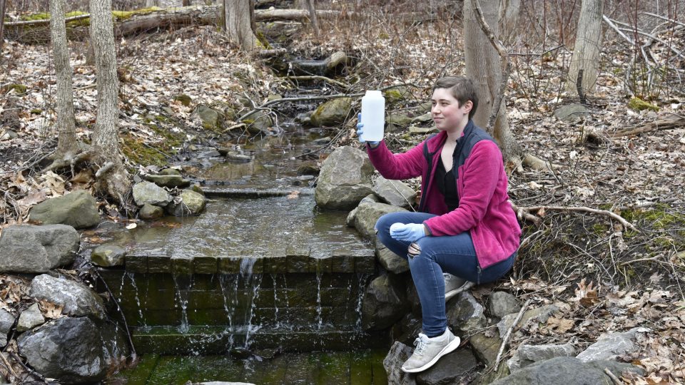 SUNY Oswego senior zoology major Jamie Perrin collects environmental DNA from recent winter melt
