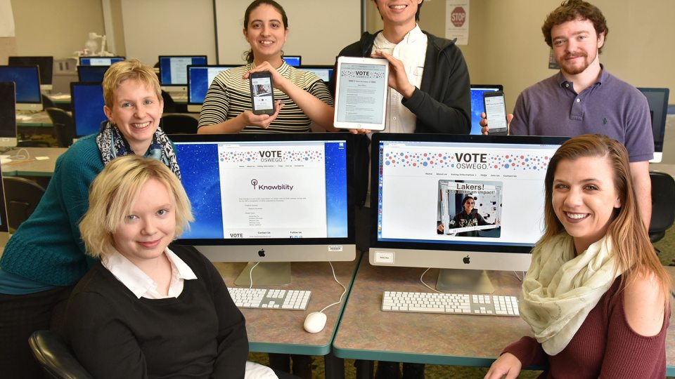 Students and faculty show off the Vote Oswego site they designed which won a national accessibility award