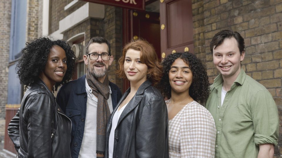 5 members of Actors from the London Stage pose outside a stage door