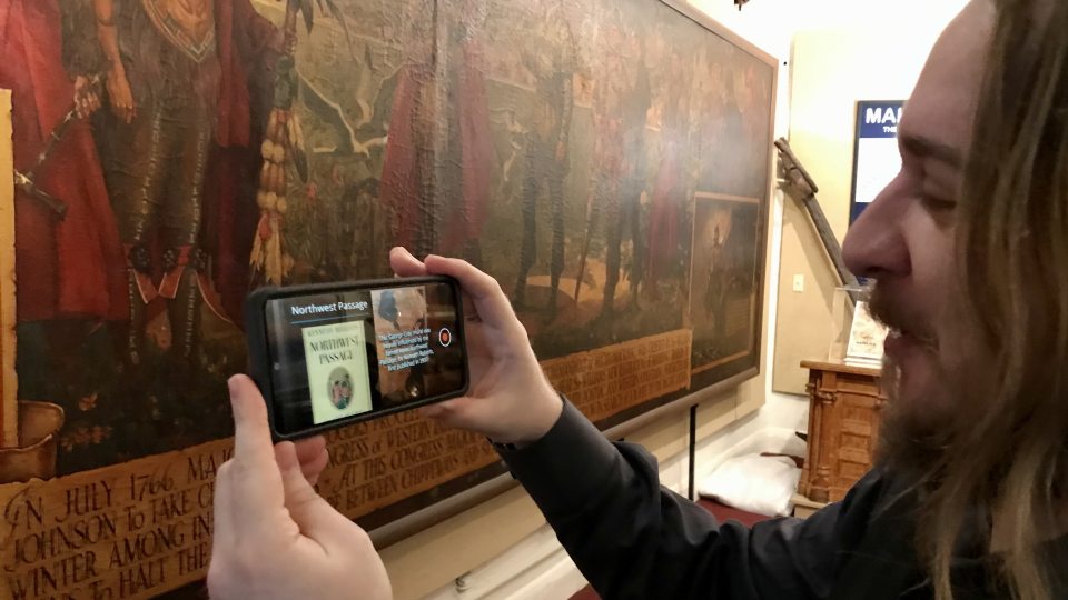 Master's in human-computer interaction student Phoenix Boisnier shows how the team's augmented reality programming will show up for a display at the H. Lee White Marine Museum in Oswego
