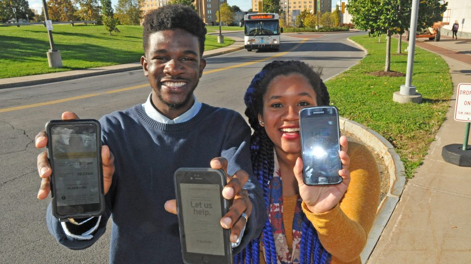Students show BusShare web app on their smartphones