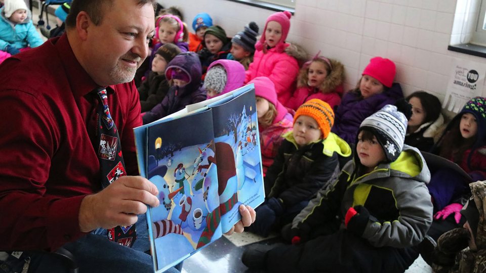 Sandy Creek Elementary School Principal Tim Filiatrault shares a book with young readers