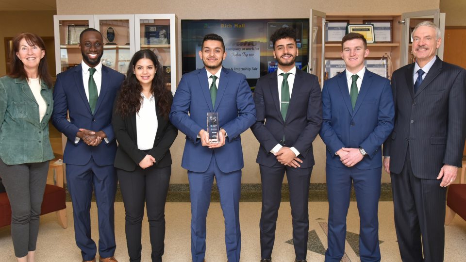 Members of Oswego's team in the SUNY Oswego CFA Research Challenge Team present Dean Richard Skolnik with a trophy