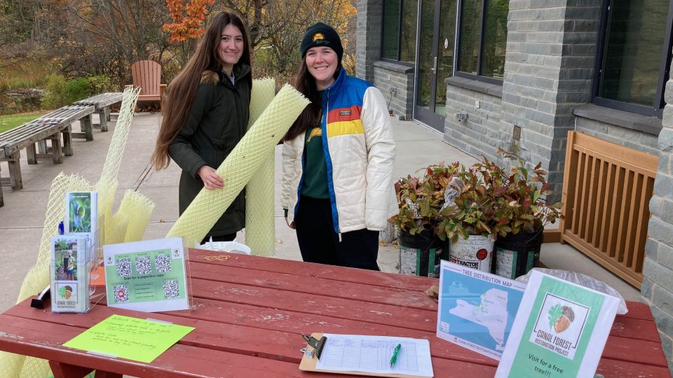 Canal Forest Restoration Project interns Julia Zinszer and Elizabeth Triana show some plants