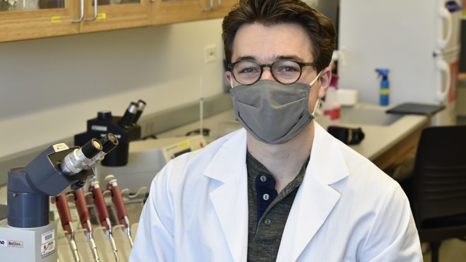 Christian DiBiase sits in a Shineman Center lab surrounded by research equipment