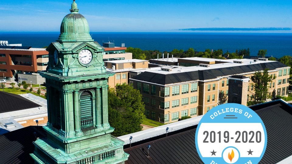 Aerial evening view of Sheldon Hall cupola with Colleges of Distinction logo