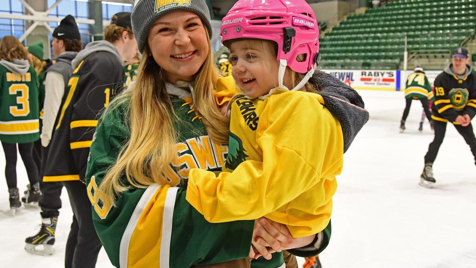 Laker women's hockey player Taylor Hudon with a young fan at the annual Holiday Skate with the Lakers