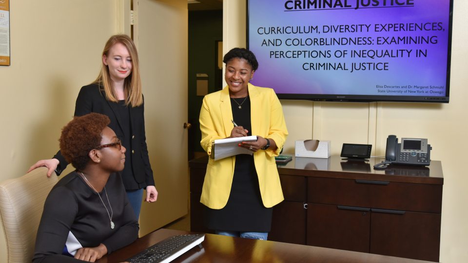 Criminal justice faculty member listening to student presentations