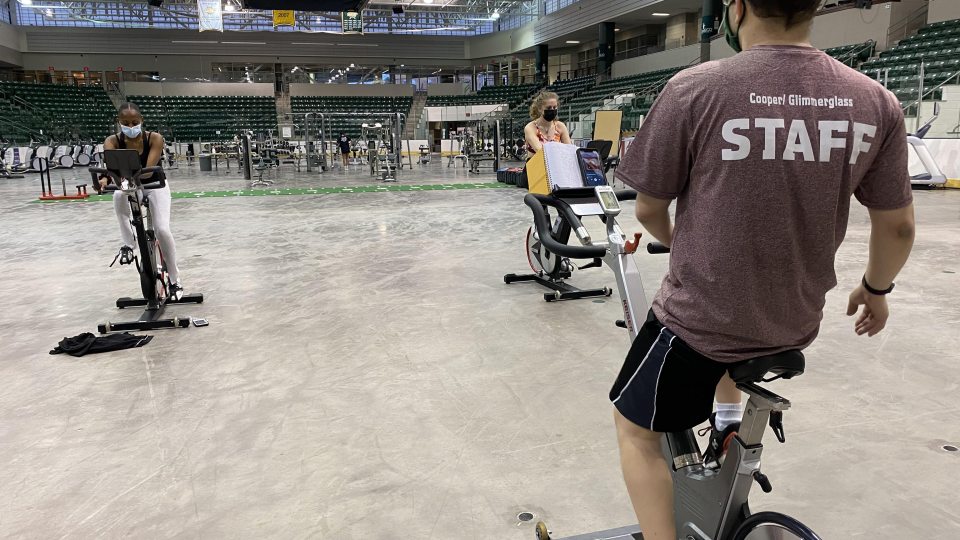 Students participate in an Indoor Cycling group workout