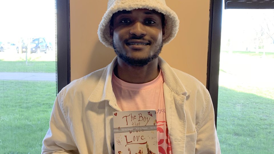 Student Horane Daley holds a copy of his book, The Boy That Wrote Love
