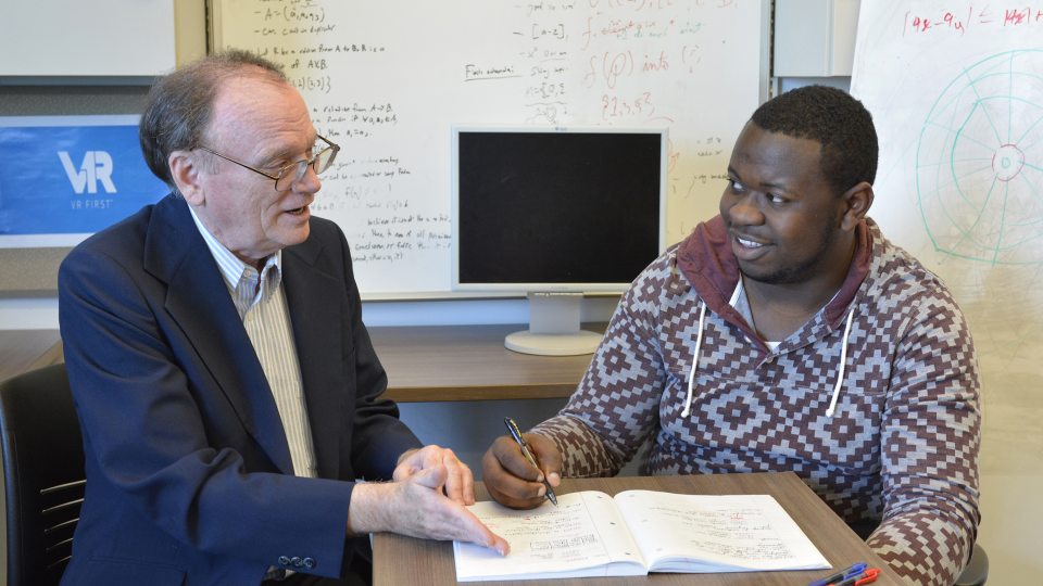 Faculty member David Vampola speaks with student Kingsley Ibezim