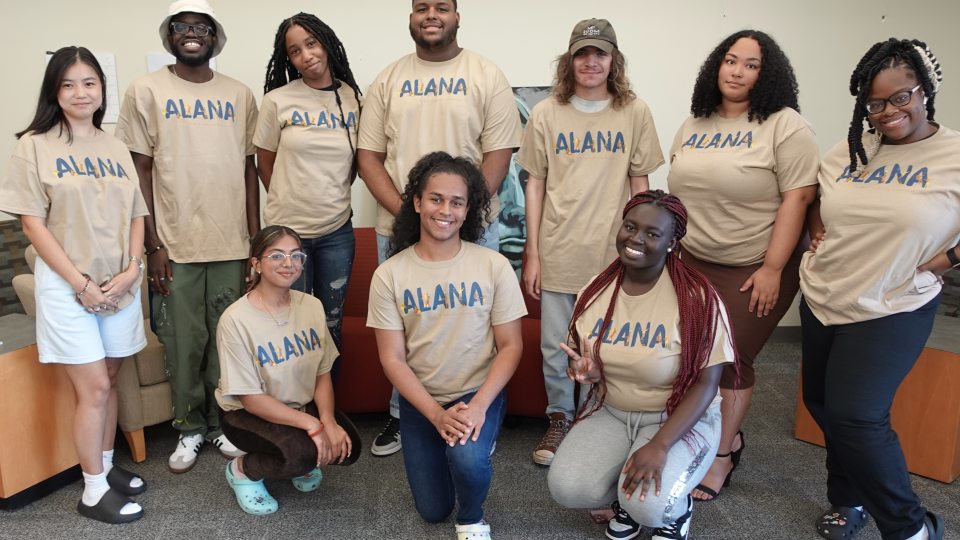 ALANA student leaders wearing tan ALANA conference shirts with blue and gold logo for the 36th annual conference themed Joyful Noise