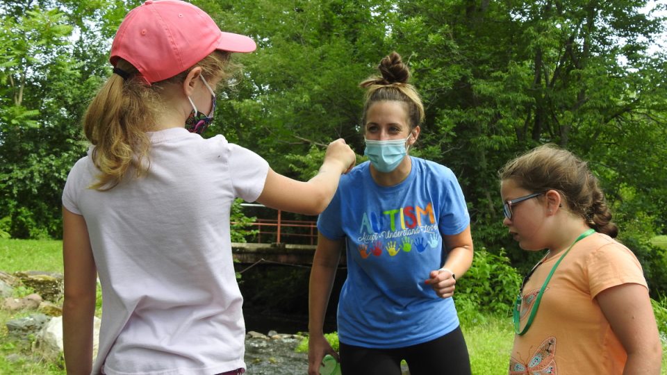 A child participating in Exploring Nature shows a finding to her teacher