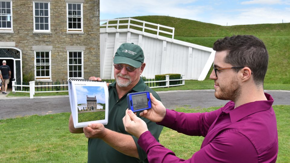 Fort Ontario's Paul Lear and SUNY Oswego graduate student Theo Johnson demonstrate an app that uses historical photos as reference points