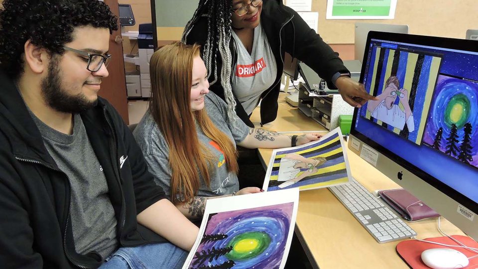 Students look at artwork submitted by schoolchildren