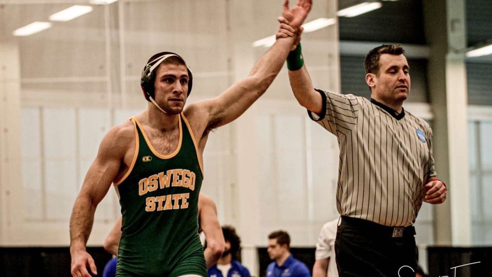 Wrestler Charles Grygas with his hand raised in victory