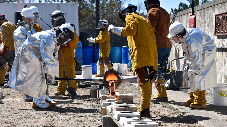 Students work with molten iron in the annual Iron Pour event