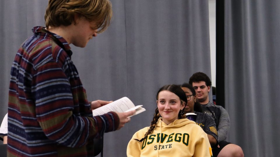 The SUNY Oswego production of  “John Proctor is the Villain” depicts teenangers exploring hardships while studying the classic novel “The Crucible." Student performers include Wells Liscomb (standing and reading) and Kamdyn Miller (front and center).
