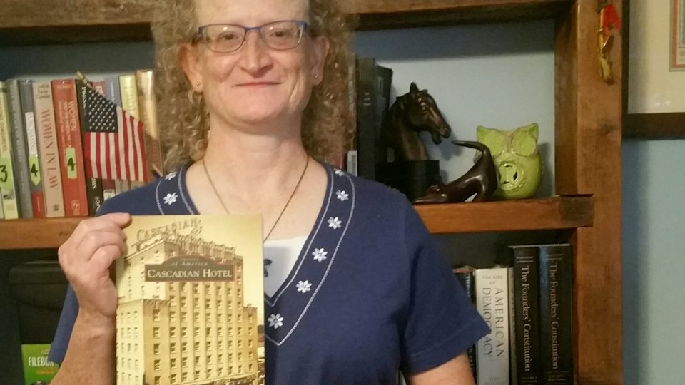 Political science faculty member Helen Knowles holds book on Cascadian Hotel